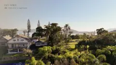 Vista aérea do terreno face norte do Cacupé Náutico Residence com jardim e mar da Baía Norte ao fundo — Cacupé 4 Náutico Residence em Cacupé, Florianópolis