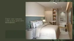 Suíte com cama de casal e solteiro, cabeceira cinza acolchoada, espelho oval, TV e janela com vista para jardim — Cacupé 4 Náutico Residence em Cacupé, Florianópolis