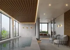 Piscina coberta do Cais by Nova com teto em treliça dourada, poltronas cinzas e janelões com jardim — Cais by Nova em Centro, Florianópolis