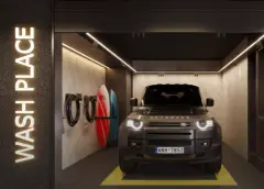 Garagem Wash Place do Cais by Nova com carro Land Rover Defender, pranchas de surf na parede e iluminação neon — Cais by Nova em Centro, Florianópolis
