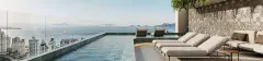 Piscina de borda infinita no rooftop do Cais by Nova com espreguiçadeiras, Baía Sul e ilhas ao fundo — Cais by Nova em Centro, Florianópolis