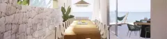 Perspectiva ilustrativa panorâmica do salão gourmet com mesa de madeira, parede em pedra e acesso para área externa com rede e mar — D/Season Residence Club em João Paulo, Florianópolis