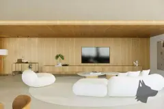 Perspectiva ilustrativa da sala de estar ampla com sofás brancos orgânicos, painel de TV em madeira, tapete circular e iluminação embutida — D/Season Residence Club em João Paulo, Florianópolis
