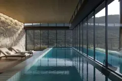 Perspectiva da piscina coberta do Dália ao entardecer com espreguiçadeiras e vista para as montanhas, ângulo alternativo — Dália em Canasvieiras, Florianópolis