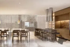 Perspectiva da área gourmet do Djalma 64 com mesa de jantar longa, ilha de mármore e coifas — Djalma 64 em Centro, Florianópolis