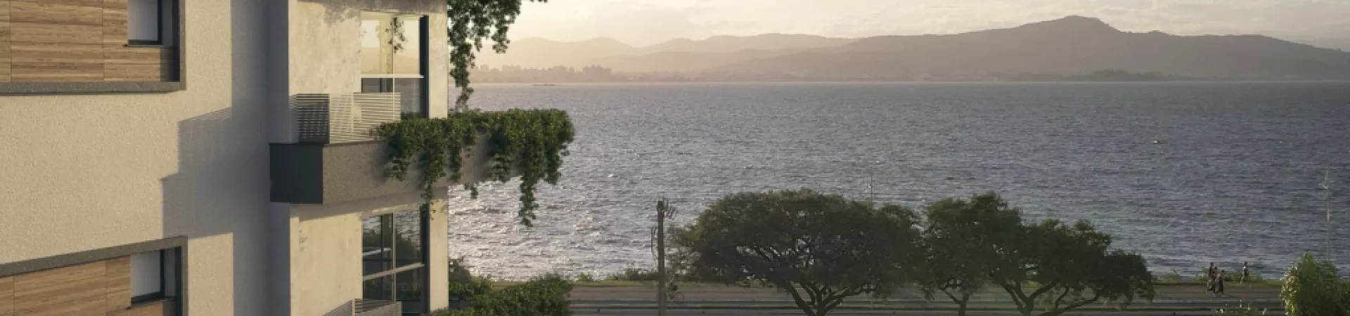 Perspectiva da sacada do Domus 544 com vista para a Baía Norte e montanhas ao entardecer — Domus 544 em Agronômica, Florianópolis