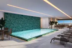 Perspectiva da piscina coberta do Essência Carlessi com revestimento verde-esmeralda, espreguiçadeiras e vista para a cidade — Essência Carlessi em Córrego Grande, Florianópolis