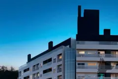 Perspectiva da fachada do Essência Carlessi ao entardecer com topo em preto e torre de vidro — Essência Carlessi em Córrego Grande, Florianópolis