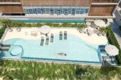 Vista aérea da piscina com formato orgânico, espreguiçadeiras dentro da água, deck em areia e fachada do edifício ao fundo — Gaivotas 4 em Ingleses, Florianópolis