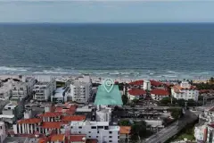 Vista aérea do terreno do empreendimento marcado com ícone de localização, com o mar de Ingleses ao fundo — Gaivotas 4 em Ingleses, Florianópolis