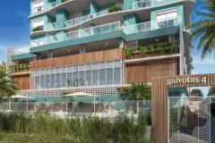 Fachada frontal do edifício Gaivotas 4 com revestimento verde-água, varandas com jardins e academia envidraçada no térreo — Gaivotas 4 em Ingleses, Florianópolis