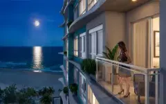 Perspectiva noturna da varanda com vista para o mar iluminado pela lua cheia e pastilhas teal na fachada — Gaivotas 4 em Ingleses, Florianópolis