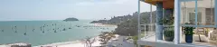 Varanda com vista panorâmica para o mar de Jurerê, veleiros ancorados, ilha ao fundo e sala de estar integrada — Galleria 50 em Jurerê, Florianópolis