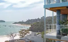 Varanda com vista para a praia de Jurerê, veleiros e ilha ao fundo, coluna revestida em pedra — Galleria 50 em Jurerê, Florianópolis
