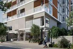 Entrada do edifício no térreo com fachada em vidro, placa Galleria 50 e pedestres na calçada — Galleria 50 em Jurerê, Florianópolis