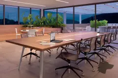 Sala de reuniões com mesa longa de madeira, cadeiras de escritório e vidros amplos com vista para varanda ao entardecer — Gran Malltech Business by Housi em Vargem Grande, Florianópolis