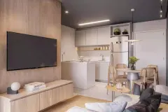 Sala de estar integrada à cozinha americana com sofá, TV em painel de madeira, mesa de jantar e geladeira — Gran Malltech Residence em Vargem Grande, Florianópolis