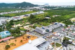 Vista aérea do empreendimento mostrando localização em Vargem Grande, Florianópolis, com o mar ao fundo — Gran Malltech Residence em Vargem Grande, Florianópolis