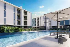 Área da piscina com deck azul, espreguiçadeiras e guarda-sol em dia ensolarado — Gran Malltech Residence em Vargem Grande, Florianópolis
