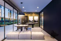 Salão de jogos com sofá modular branco, mesa redonda, mesa de air hockey e quadros na parede — Gran Malltech Residence em Vargem Grande, Florianópolis