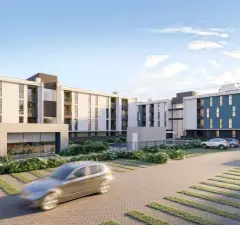 Vista dos dois blocos com carro em movimento no estacionamento ao entardecer — Gran Malltech Residence em Vargem Grande, Florianópolis