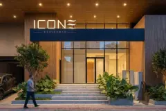 Entrada principal do edifício à noite com letreiro Icone Residence, escadaria, vegetação e hall envidraçado — Icone Residence em Ingleses, Florianópolis