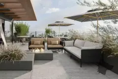 Render do rooftop com sofás, mesa de fogo e plantas ornamentais, ângulo frontal — Imob Canas em Canasvieiras, Florianópolis