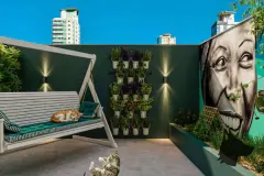 Varanda lounge com balanço de madeira, jardim vertical com vasos e mural feminino em grafite, gatos presentes — Imob Trindade On em Trindade, Florianópolis