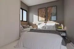 Dormitório com cama de casal, cabeceira em madeira, quadros de paisagem aérea e banco de canto com almofadas — Imperial Residence em Campeche, Florianópolis