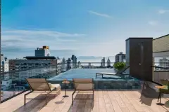 Rooftop com piscina infinita, espreguiçadeiras e vista panorâmica para o centro de Florianópolis, Baía Norte e montanhas — In Haus Afonso Pena em Canto, Florianópolis