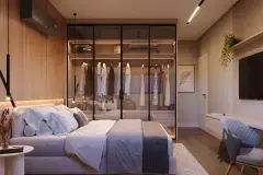 Suíte com cama de casal, closet de vidro iluminado com armações metálicas, TV e cadeira de trabalho — In Haus Afonso Pena em Canto, Florianópolis
