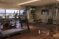 Academia com esteiras, bicicleta ergométrica, aparelhos de musculação e janelas com vista para a cidade — In Haus Afonso Pena em Canto, Florianópolis