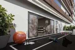 Área de atletismo ao ar livre com pista de corrida, bola de pilates e academia com parede de vidro ao fundo — Infinite Campeche em Campeche, Florianópolis