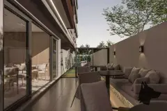 Terraço térreo com sofás externos, mesas e visão para o salão interno com mural artístico — Infinite Campeche em Campeche, Florianópolis