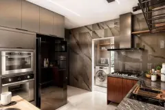 Cozinha com armários escuros, revestimento de pedra, forno embutido, geladeira e área de lavanderia integrada — Infinity Residence em Ingleses, Florianópolis