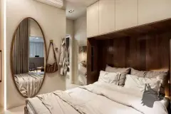 Quarto com espelho oval de pé, armário embutido com madeira escura e roupa de cama cinza — Infinity Residence em Ingleses, Florianópolis