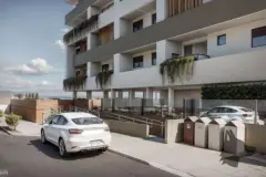 Perspectiva frontal do edifício com fachada branca, painéis de madeira e carros estacionados na entrada — Infinity Residence em Ingleses, Florianópolis