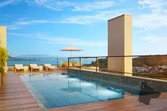 Piscina no rooftop com deck de madeira, espreguiçadeiras e vista panorâmica para a baía — Jardim Cacupé Residence em Cacupé, Florianópolis