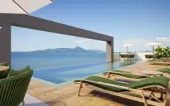 Piscina infinita no rooftop com espreguiçadeiras verdes e vista para as ilhas da Baía Norte — Jardim de Coqueiros em Coqueiros, Florianópolis
