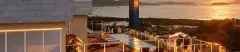 Foto do rooftop do Lazuli Residence ao entardecer com piscina de borda infinita e vista para o mar e ilhas de Ponta das Canas — Lazuli Residence em Ponta das Canas, Florianópolis