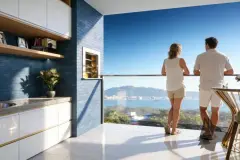 Perspectiva da varanda-gourmet com casal apreciando a vista para o mar em Ponta das Canas — Lazuli Residence em Ponta das Canas, Florianópolis