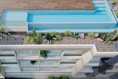 Perspectiva do topo do edifício com piscina de borda infinita e jardim xerófito — Lazuli Residence em Ponta das Canas, Florianópolis