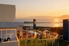 Perspectiva do rooftop do Lazuli Residence ao entardecer com piscina e vista para o oceano — ângulo alternativo — Lazuli Residence em Ponta das Canas, Florianópolis