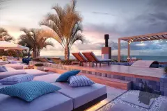 Perspectiva da área de lazer do rooftop do Liv 2460 com espreguiçadeiras, piscina e vista para o mar ao entardecer — LIV 2460 Boutique Residence em João Paulo, Florianópolis