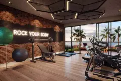 Perspectiva da academia do Liv 2460 com parede de tijolos, equipamentos e vista para as palmeiras ao entardecer — LIV 2460 Boutique Residence em João Paulo, Florianópolis