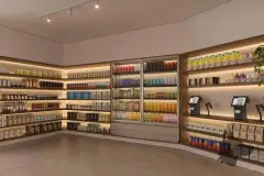 Perspectiva ilustrativa da loja de conveniência do condomínio com prateleiras iluminadas, geladeiras e caixa de autoatendimento — Lumina Residence em Cachoeira do Bom Jesus, Florianópolis