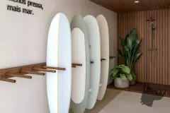 Área de guarda de pranchas de surf com racks de madeira e chuveiro externo ripado — Lunáh Blue View em Campeche, Florianópolis