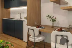 Perspectiva da cozinha compacta com armários azuis, bancada de mármore e mesa de refeições para dois — Lunáh Blue View em Campeche, Florianópolis