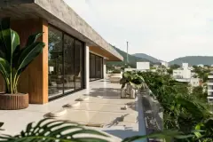Terraço com espaço para yoga e meditação, almofadas no piso e vista para a cidade e morros — Lunáh Blue View em Campeche, Florianópolis