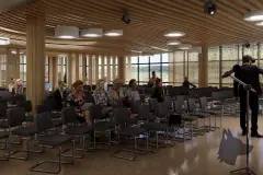 Perspectiva do auditório do Maldivas Spa Urbano com fileiras de cadeiras e painéis ripados — Maldivas SPA Urbano em Ingleses, Florianópolis